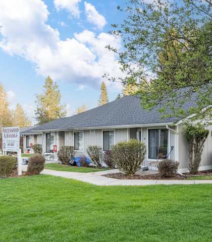 a white house with a yard and a tree