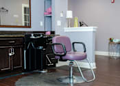 Thumbnail 3 of 4 - A purple chair sits in front of a black stove in a kitchen.
