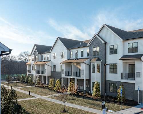 A row of modern houses with a clear blue sky above them.
