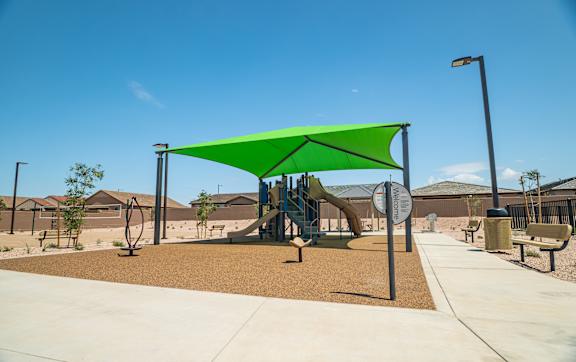 A playground with a green canopy and a slide.