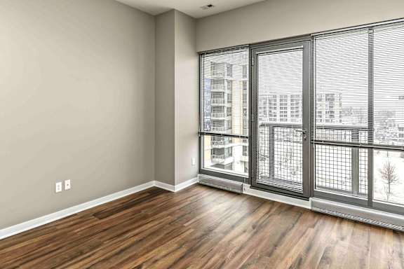floor to ceiling windows in a living room with warm brown wood floors
