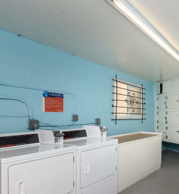 a laundry room with white washers and dryers