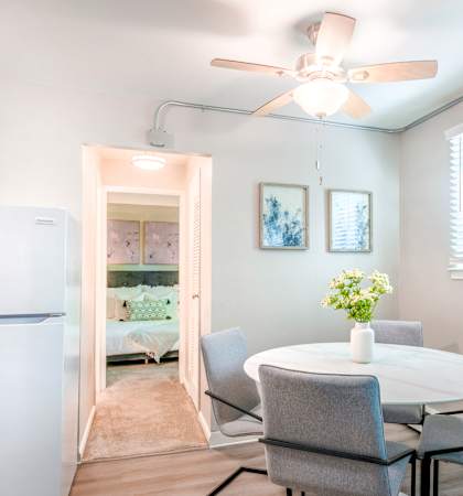 a dining room with a table and chairs and a ceiling fan