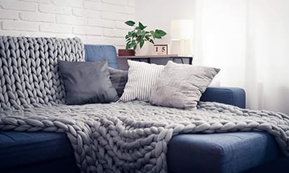 Blue couch with pillows and coffee table