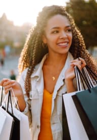 Woman Smiling while Holding Shopping Bags