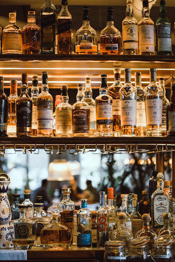 A shelf of liquor bottles in a bar.