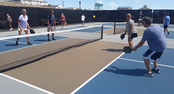 a group of people playing tennis on a tennis court