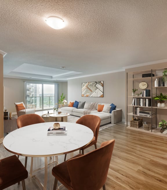 a dining area with a round table and chairs and a living room with a couch and a