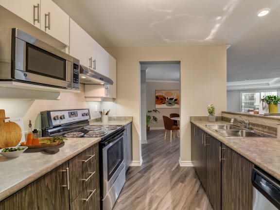 a kitchen with white countertops and wooden cabinets