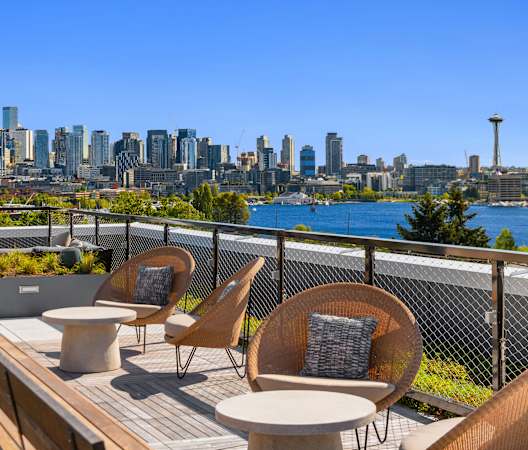 a rooftop deck with chairs and tables with a view of the city at Liza Apartments, Washington