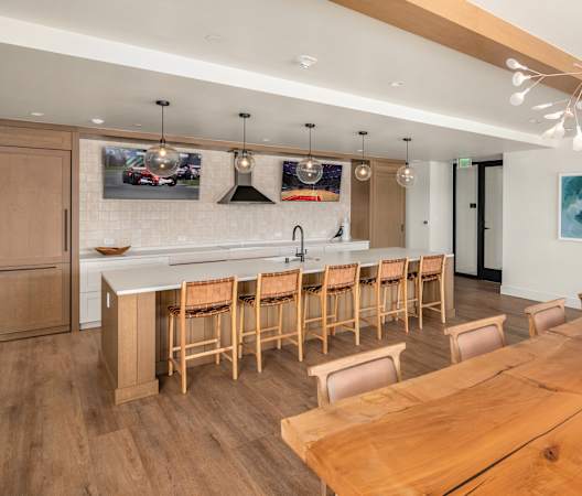 a kitchen and dining room with a wooden table and chairs at Liza Apartments, Washington