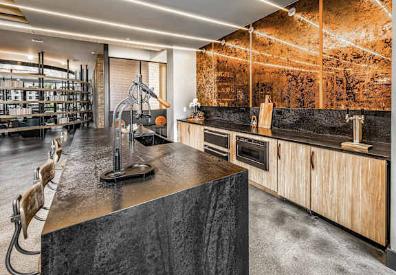 a kitchen with concrete countertops and wooden cabinets and a wine cellar at The Overlook in Winter Garden, FL