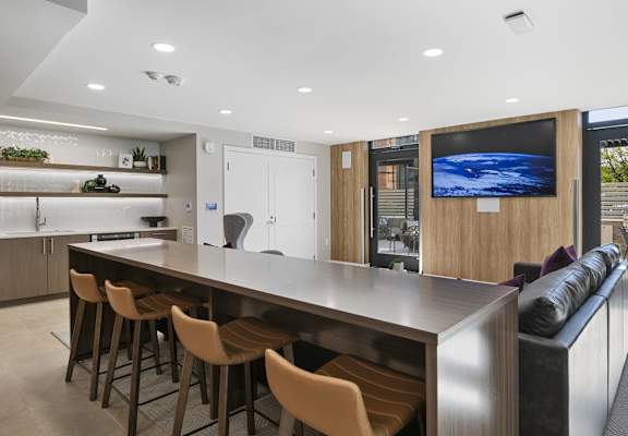 a kitchen with a bar and a living room with a couch