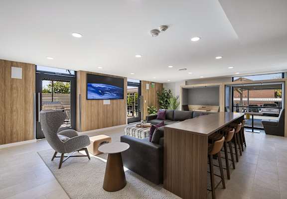 a kitchen and living room with a bar and a television