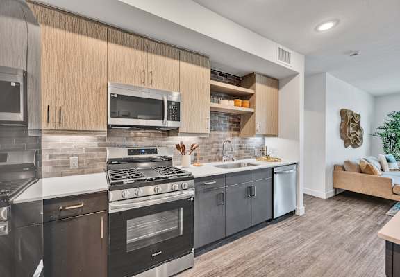 A modern kitchen with dark wood cabinets and stainless steel appliances.