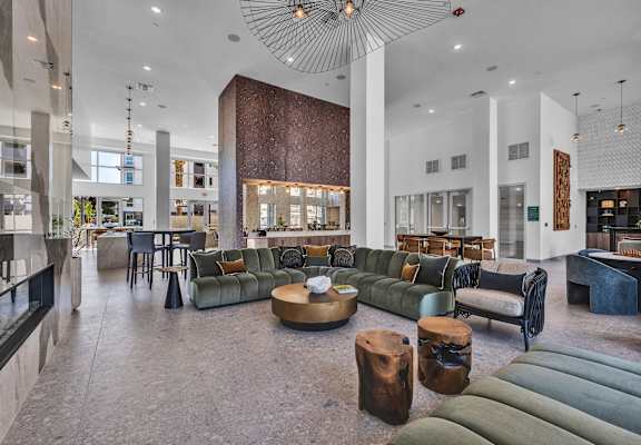 A large room with a lot of furniture and a circular light fixture hanging from the ceiling.