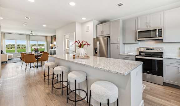 an open kitchen with a large island with bar stools