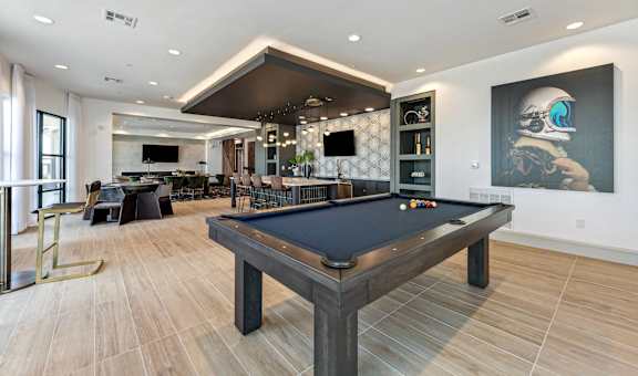 a billiards table in a clubhouse with a bar and a television