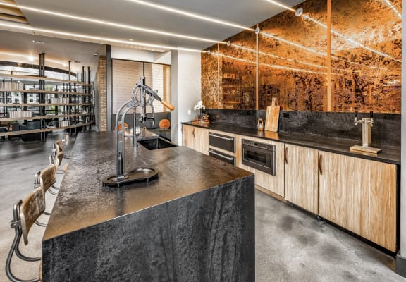 a kitchen with concrete countertops and wooden cabinets and a wine cellar