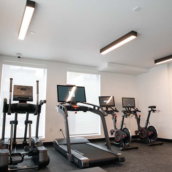 a gym with various exercise machines and mirrors