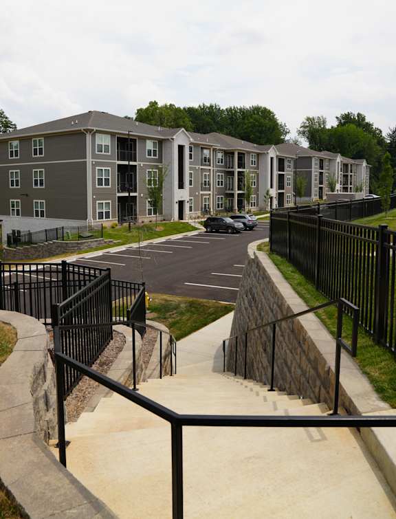 A concrete staircase with metal railings leads up to a building.