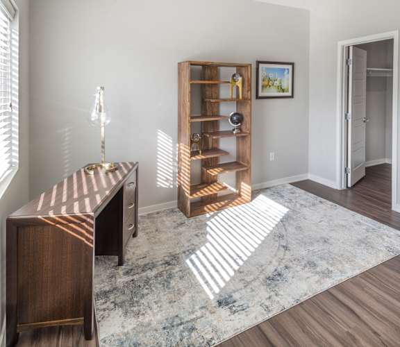 A room with a wooden bookcase and a rug on the floor.