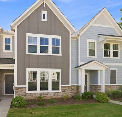 A row of houses with different shades of grey and white.