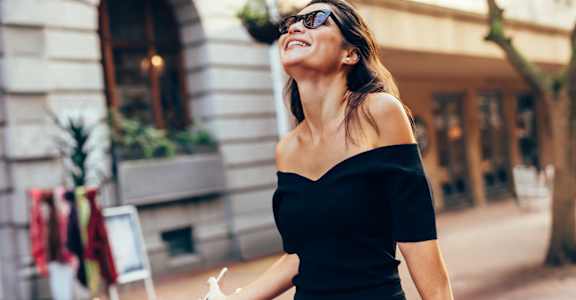 a woman in a black dress holding a shopping bag