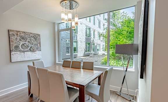 a dining room with a large window and a table with chairs