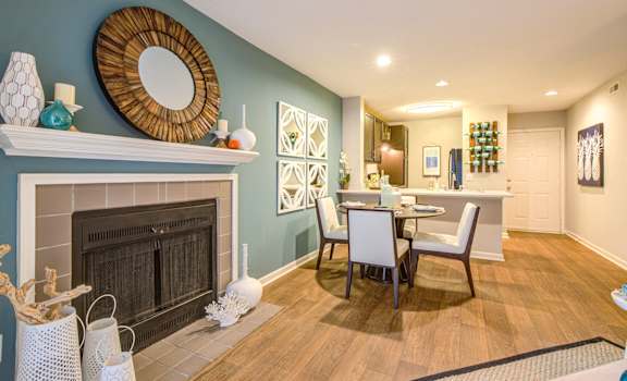 A living room with a fireplace and a dining table at Waverly Place, North Charleston, SC, 29418
