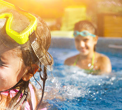 Two Little Girls Playing in Pool with Goggles On