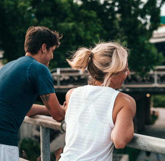 a man and a woman looking over a bridge