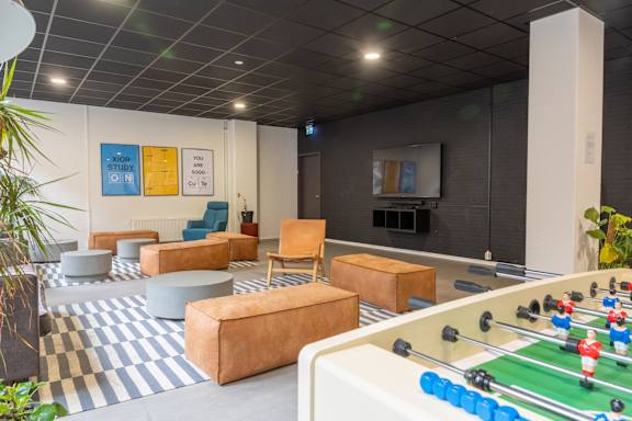 A foosball table is in the middle of a room with a blue and white checkered floor.