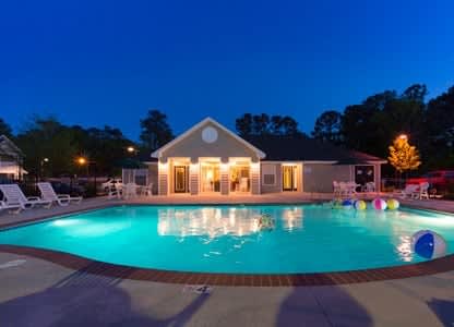 a large swimming pool with a house in the background