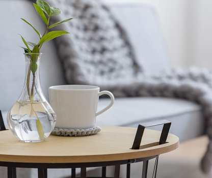 a vase with a plant on a table next to a cup of coffee at River Stone Ranch, Austin