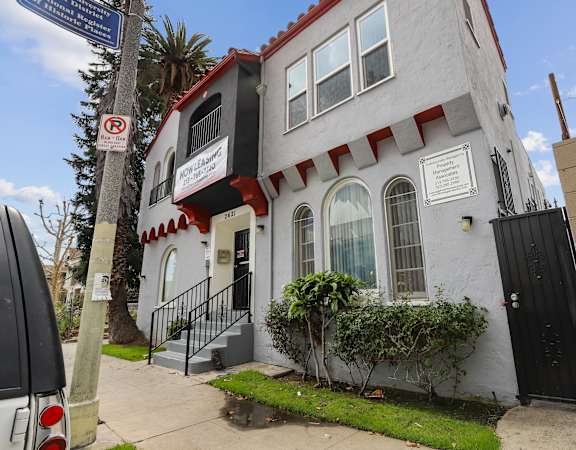 A white building with a red trim and a black door.