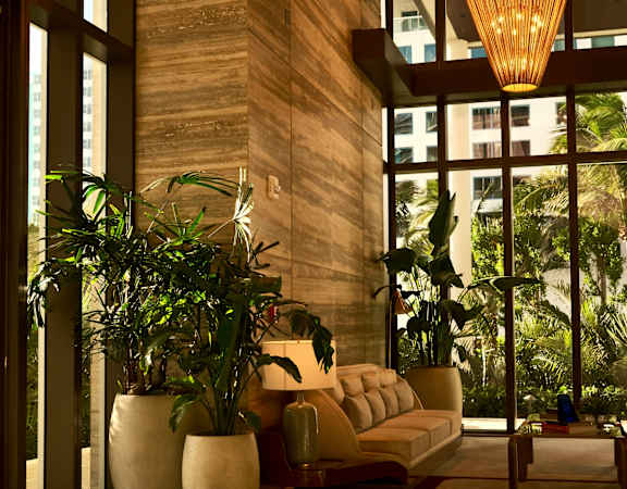A large, well-lit lobby with a checkered floor and a large hanging light fixture.