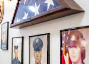 Thumbnail 7 of 29 - A wall with a framed American flag and three framed portraits of military personnel.at Spring Arbor of Wilson, Wilson, 27893-2873