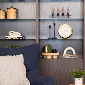 a blue chair with a white pillow in a living room