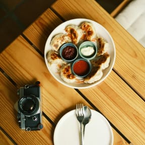 a plate of food on a table with a fork and a camera