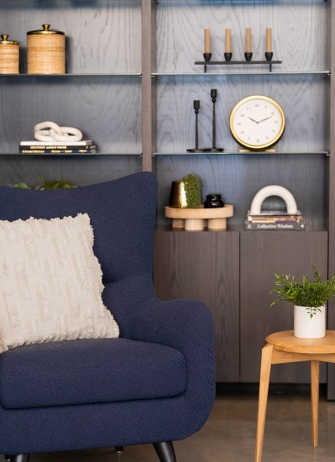 A blue chair with a white pillow in a living room at Kesler Apartments in Downtown Fargo, Fargo, North Dakota, 58102