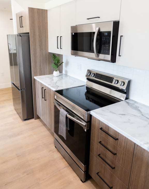 a modern kitchen with stainless steel appliances and white cabinets