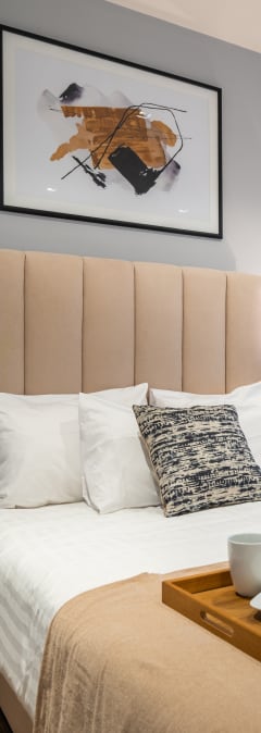 a bedroom with a bed and a tray with a cup and saucer on it
