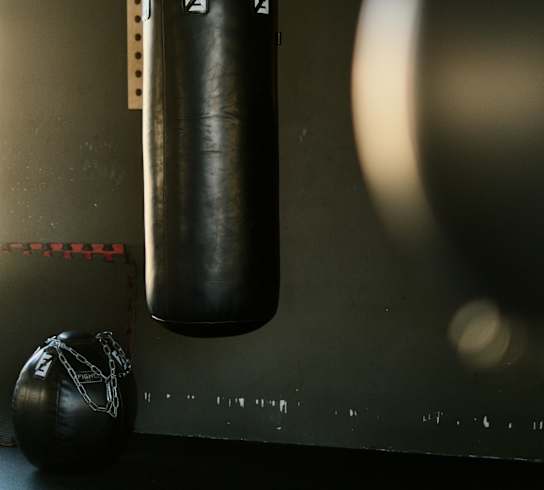 A punching bag hanging from a chain in a gym.