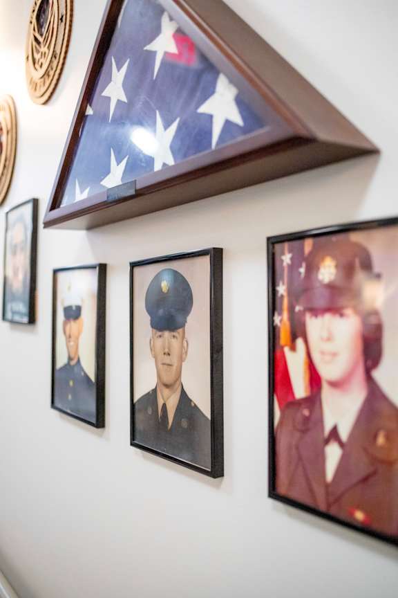 A wall with a framed American flag and three framed portraits of military personnel.at Spring Arbor of Wilson, Wilson, 27893-2873