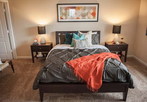 a bedroom with a bed and two nightstands and a couch