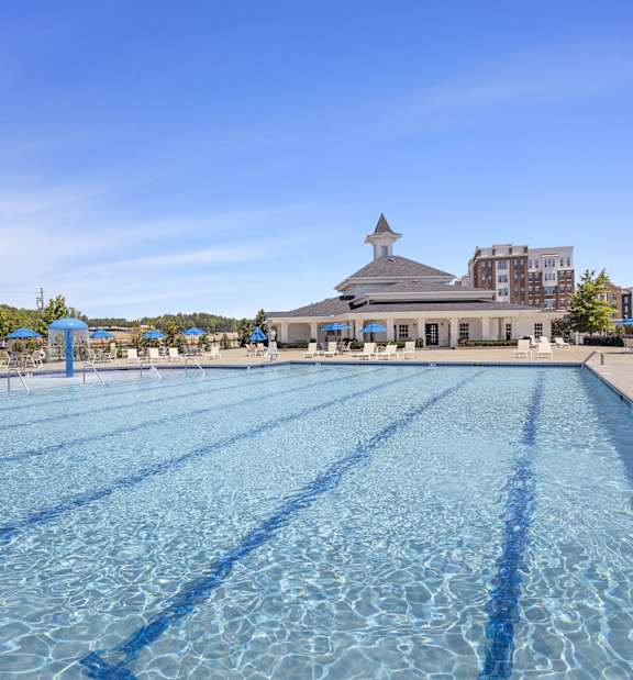 A large swimming pool with a building in the background.
