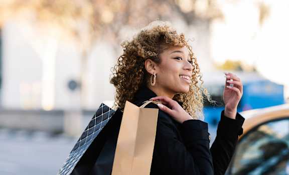 a woman with curly hair holding a shopping bag at The Rialto, Florida, 32819