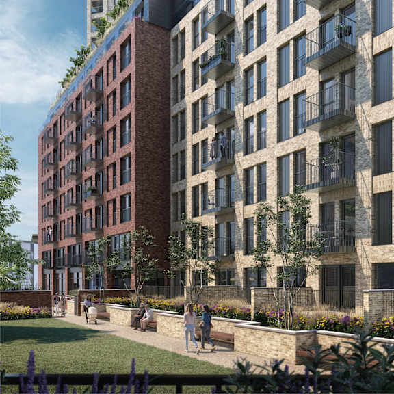 A modern apartment complex with balconies and a garden area.