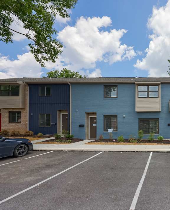 A row of townhouses with a car parked in front.